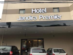 dois carros estacionados em frente a um hotel jamba premier em Jandira Premiêr Hotel em Jandira