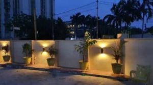a group of potted plants on a wall with lights at Presken Hotels @ Victoria Island in Apese