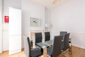 a dining room with a glass table and black chairs at Spacious 4 bed with Parking near Nottingham City Centre - 184 Gregory House in Nottingham