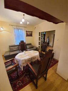 - un salon avec une table, des chaises et un canapé dans l'établissement Willa Widok, à Nałęczów
