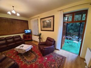 a living room with a leather couch and a table at Willa Widok in Nałęczów