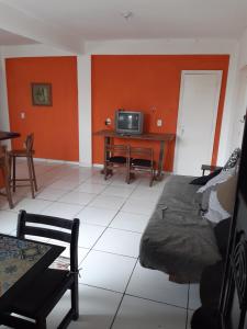 sala de estar con sofá y TV en Casa Sustentável em Figueira, Arraial do Cabo, en Arraial do Cabo