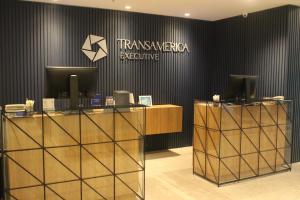 a lobby with a reception desk and a sign on a wall at Transamerica Executive Bela Cintra (Paulista) in Sao Paulo