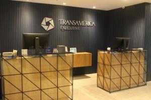 a lobby with a reception desk and a sign on a wall at Transamerica Executive Bela Cintra (Paulista) in São Paulo