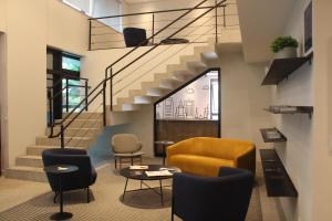 a living room with a staircase and chairs at Transamerica Executive Bela Cintra (Paulista) in Sao Paulo