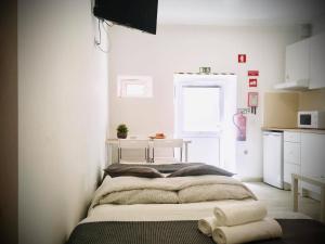 a bedroom with a bed with towels on the floor at 3stúdio in Peniche
