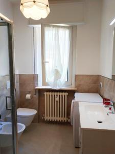 a bathroom with a sink and a toilet and a window at le case di Giulia in Abbadia Lariana