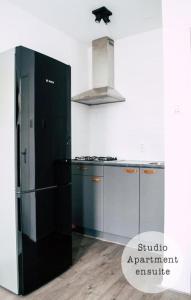 a kitchen with a black refrigerator and a stove at Rembrandt Square Hotel in Amsterdam