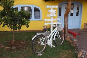 una bicicleta estacionada frente a una casa con un cartel en la calle en Hotel Catavento, en Cristalina