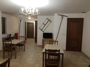 una sala da pranzo con tavoli, sedie e lampadario a braccio di La Misun de Ciafrè a Casteldelfino