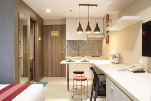 Una cocina con encimera y dos taburetes de bar. en Nginap at Student Park Apartment, en Yogyakarta