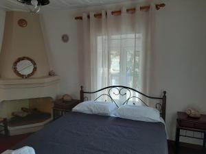 um quarto com uma cama e uma janela em Chiona΄s Apartments by the Sea em Palaión Trikérion