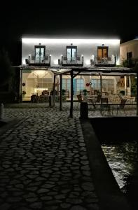 un edificio illuminato di notte con un patio in pietra di Afrodite Luxury Rooms a Calimno (Kalymnos)