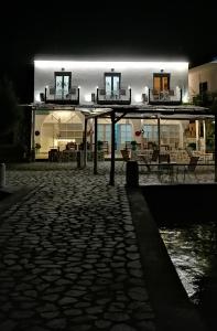 a building lit up at night with a stone patio at Afrodite Luxury Rooms in Kalymnos