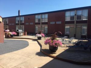 un bâtiment avec des bancs et des fleurs dans une cour dans l'établissement Boarders Inn & Suites by Cobblestone Hotels - Grand Island, à Grand Island