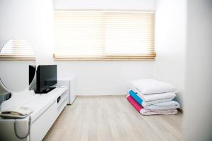 a white room with a desk with a computer and towels at Ari House in Seoul +64 photos
