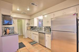 a large kitchen with a stainless steel refrigerator at Palm Desert Abode Pool, Walk to El Paseo District in Palm Desert