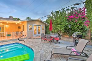 a backyard with a pool and a table and chairs at Palm Desert Abode Pool, Walk to El Paseo District in Palm Desert