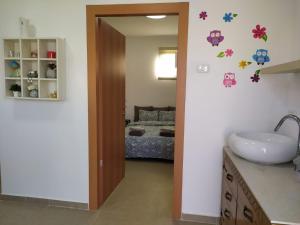 1 dormitorio con 1 cama y baño con lavabo. en the comfort place רותם המדבר, en Merhav Am