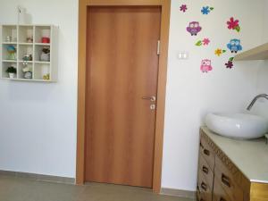 ein Badezimmer mit einer Holztür neben einem Waschbecken in der Unterkunft the comfort place רותם המדבר in Merhav Am