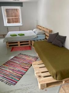 two beds in a room with two rugs at Piebalgas street apartment in Cesis in Cēsis