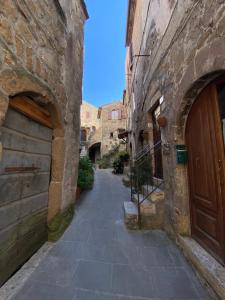 un callejón en un casco antiguo con edificios de piedra en Le Casette nel Borgo Vicolo di Siena, en Pitigliano