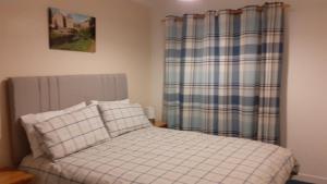 a small bedroom with a bed and a plaid curtain at Ideal Central Edinburgh location with free on-site private parking in Edinburgh