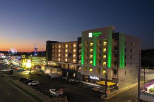 a hotel building with green lights on it at night at Holiday Inn & Suites Pigeon Forge Convention Center, an IHG Hotel in Pigeon Forge