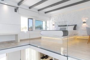 a bedroom with a bed and a glass wall at Marina's Suites in Naxos Chora
