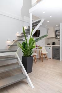 a staircase in a living room with a plant at Marina's Suites in Naxos Chora