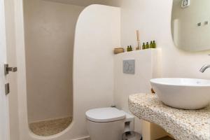 a white bathroom with a sink and a toilet at Marina's Suites in Naxos Chora