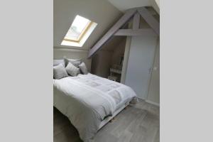 ein Schlafzimmer mit einem weißen Bett und einem Fenster in der Unterkunft Gîte de Brunemont in Diéval