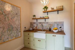 a kitchen with a sink and a map on the wall at Whicham Hall in Silecroft