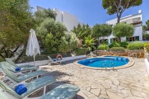 einen Pool mit zwei Liegestühlen und einem Sonnenschirm in der Unterkunft Villa Cala dor in Cala d´Or