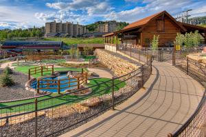 un parc avec une aire de jeux et un bâtiment en bois dans l'établissement Torian Plum Creekside II, à Steamboat Springs