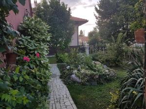 a garden with a brick walkway next to a house at Apartment Sunce in Sremska Mitrovica