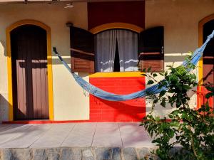 a house with a hammock in front of it at Pousada Viva Mar in Saquarema