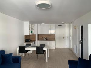 a kitchen and living room with a table and chairs at Apartament Emilia Ustronie Morskie in Ustronie Morskie