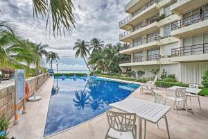 女人岛Ocean-View Oasis on Playa Norte Resort Amenities的建筑物旁边有一张桌子和椅子的游泳池