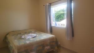 a bedroom with a bed and a window at Pousada Viva Mar in Saquarema