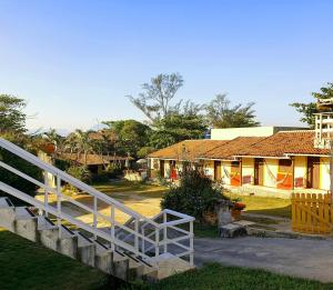 a wooden bridge over a yard with houses at Pousada Viva Mar in Saquarema