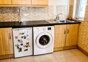 a kitchen with a washing machine and a sink at Moat Holiday Rental in Lisnaskea