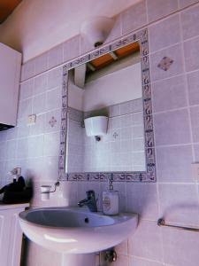 a bathroom with a sink and a mirror at Claves Claustri - Appartamento storico con balcone in Sarteano