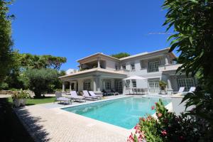 a house with a swimming pool in front of it at Charming Exceptional Golf Villa in Algarve in Faro