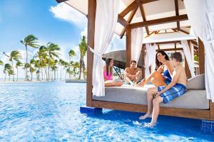 a group of people sitting on a bed in the water at Hyatt Ziva Cap Cana in Punta Cana