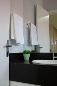 a bathroom with a black counter with a sink and a mirror at Pureza Hotel in Timon