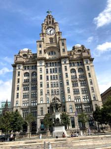 un edificio con una torre dell'orologio sopra di Excelsior Apartment - Liverpool City Centre Free Parking a Liverpool