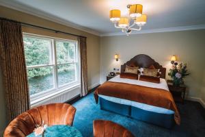 格拉斯米尔Bridge House Hotel & Silver Howe View Cottage的一间有一张床和两把椅子的卧室