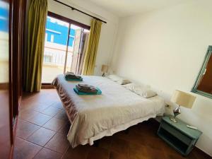 Un dormitorio con una cama y una ventana grande. en The Penthouse Puerto de Mogán, en Puerto de Mogán