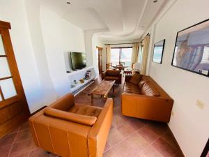 a living room with two couches and a tv at luxury penthouse with ocean and beach views in Puerto de Mogan in Puerto de Mogán